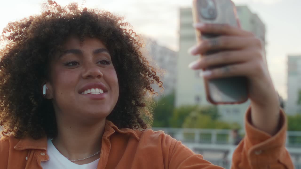 Close up of black woman standing on the bridge and having a video call