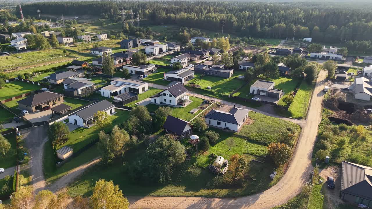 Letecký pohled dronem na předměstské domy vedle lesa v okrese Gilužiai, Litva
