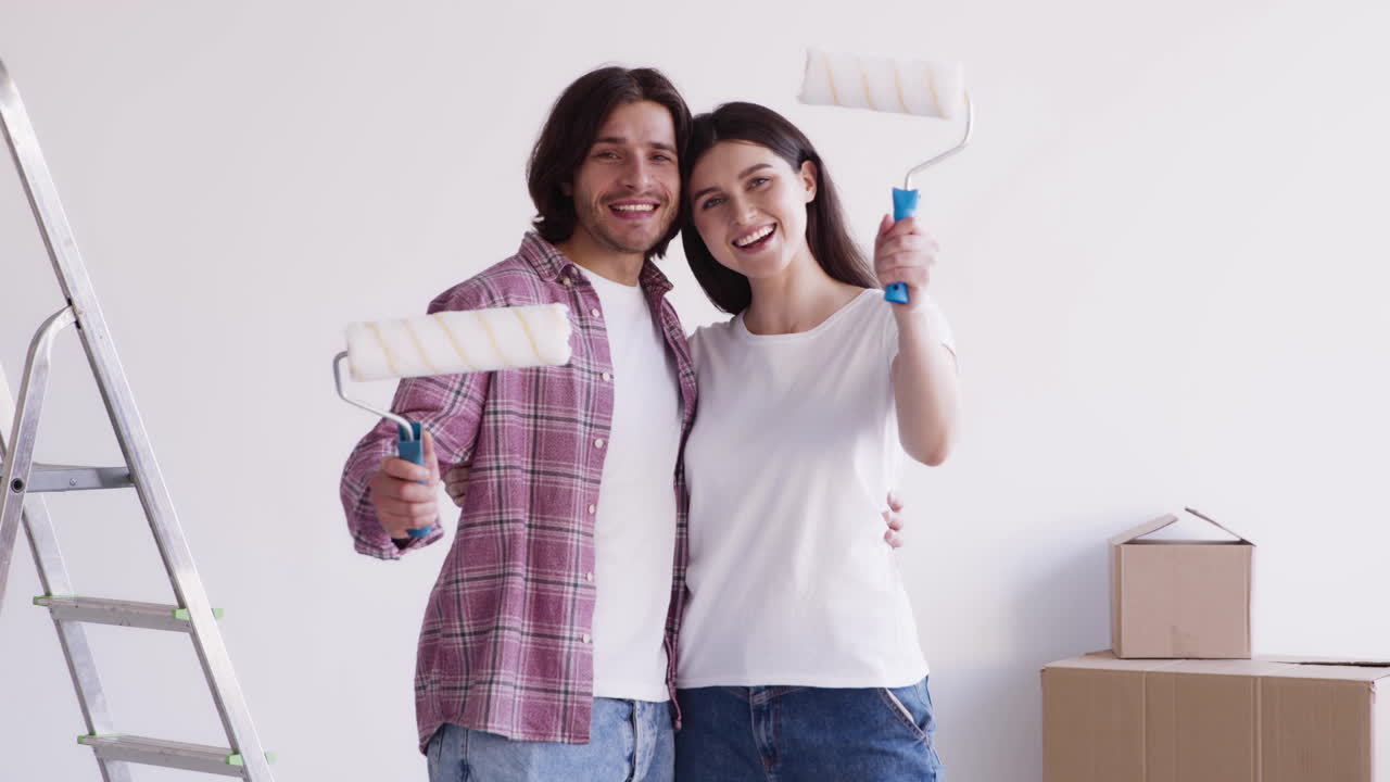 um casal feliz a pintar a sua nova casa.