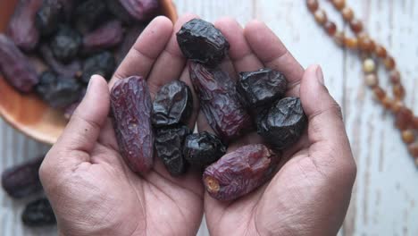 fruta de dátiles en la mano del hombre, vista de arriba