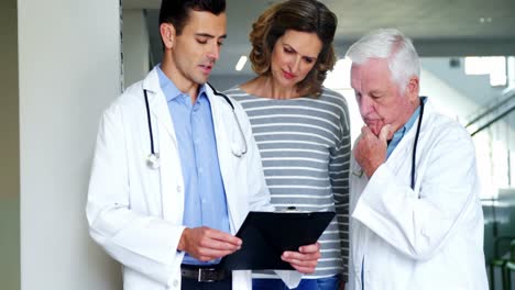 madre y médicos discutiendo sobre el clipboard