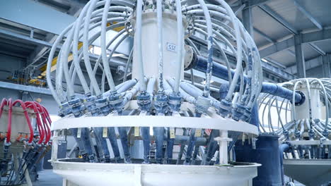 white liquid coming out from the pipes attached to the tank. automated kaolin clay production at the modern factory.