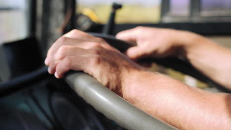 close up slow motion of hands holding steering wheel during bus ride in summertime