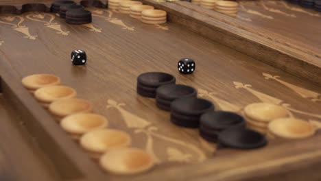 hand throws dice on a backgammon board