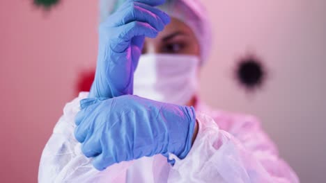 doctor in white protecting costume wearing gloves on hospital room ready to visit the patients infected by coronavirus