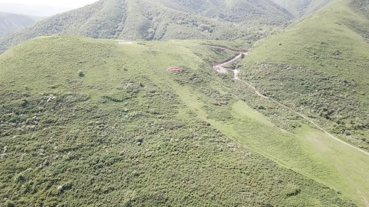 parapenteo en las montañas, campos verdes, colinas