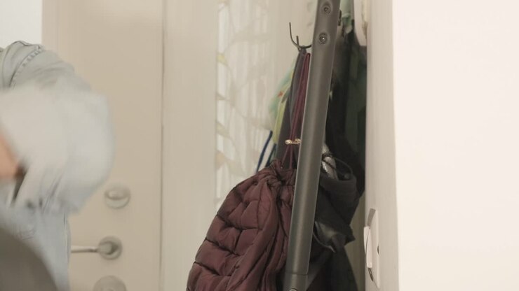 Getting ready: a man slips into his stylish leather jacket and wears his hat, preparing to face the world