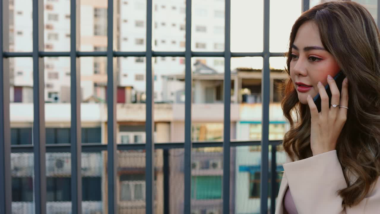 지붕 위에 있는 친구와 전화로 얘기하는 걸 즐기는 여자.