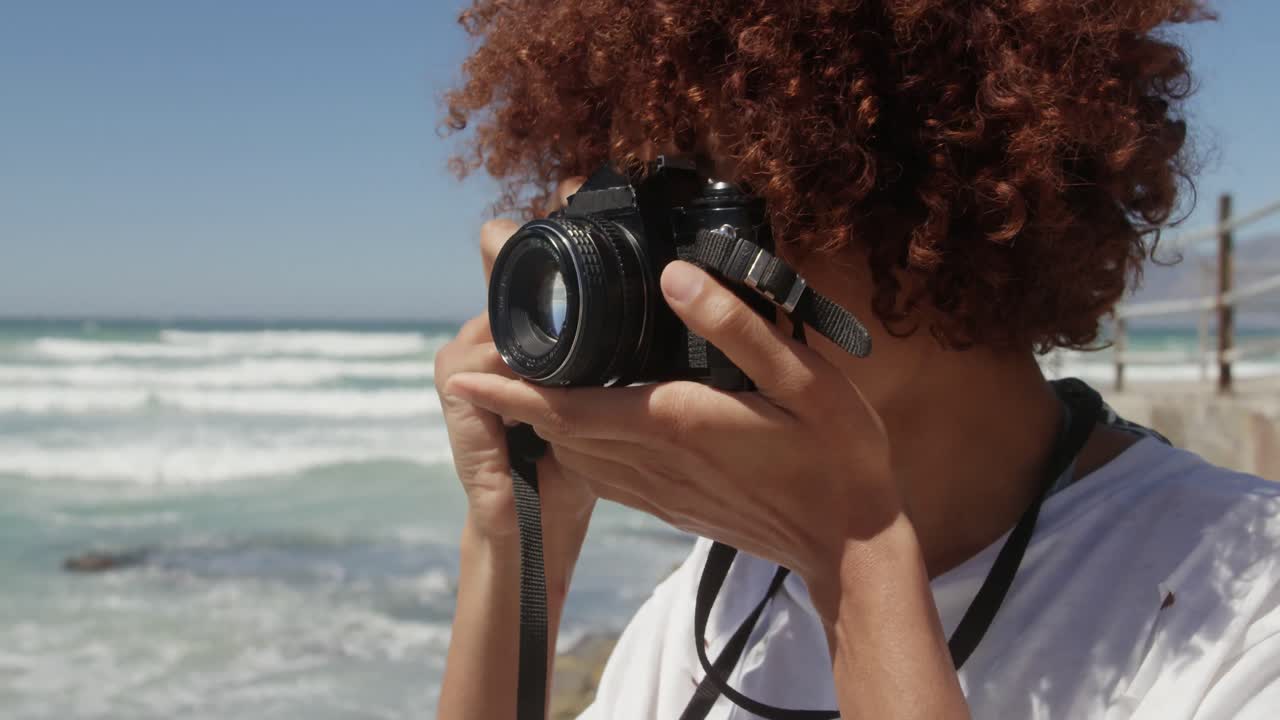 mujer tomando fotos con cámara digital en la playa 4k