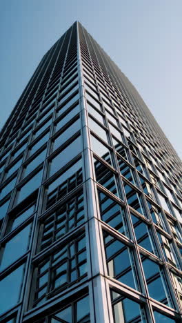 modern skyscraper with glass facade against a blue sky