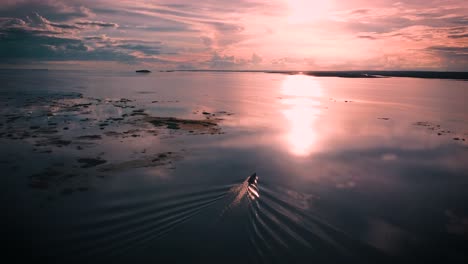 vista aérea de un barco en movimiento en el río con una hermosa puesta de sol