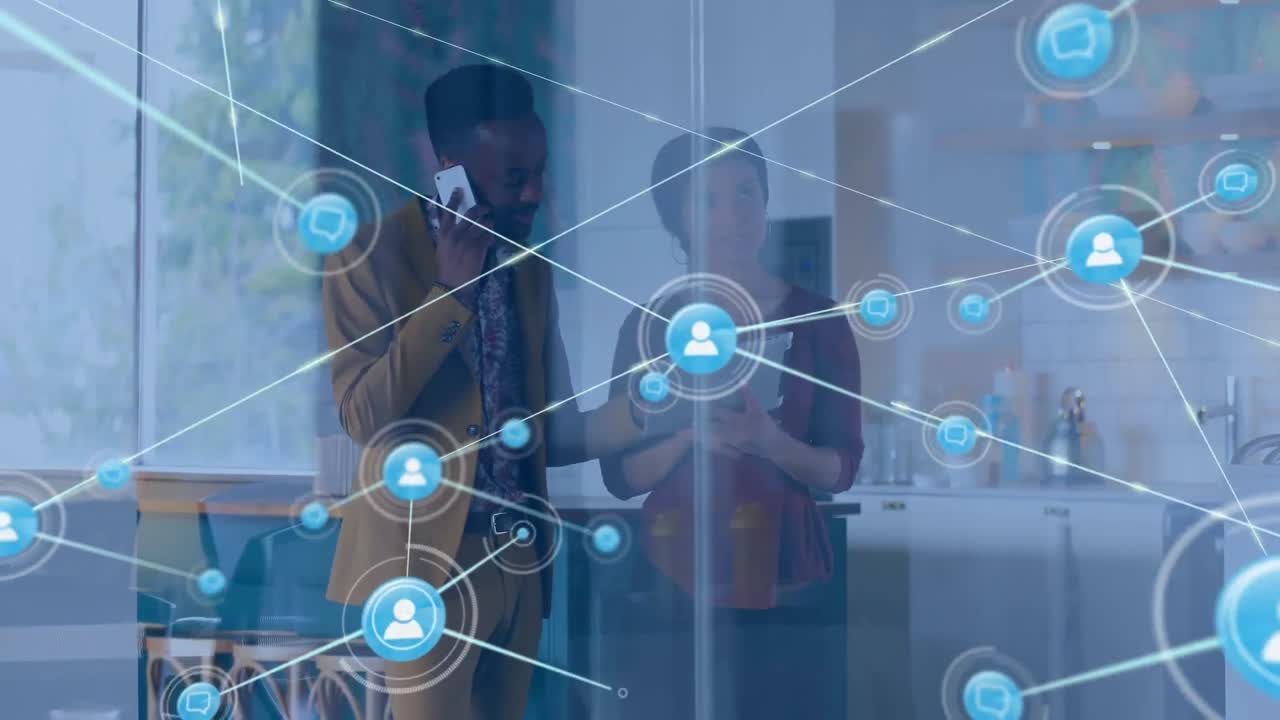 Animation of network of digital icons over diverse man and woman discussing at office