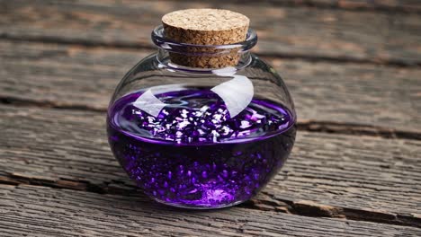 Purple Potion in Glass Bottle on Wooden Table