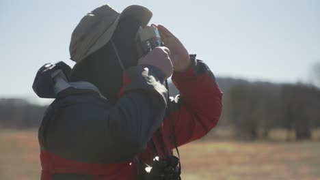 Hombre-En-La-Naturaleza-Tomando-Fotografías-Y-Mirando-Con-Sus-Binoculares