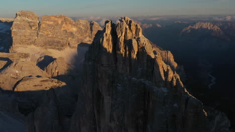 filmische drohnenaufnahme von tre cime di lavaredo in italien, mit felsigen bergen, die den gipfel umgeben