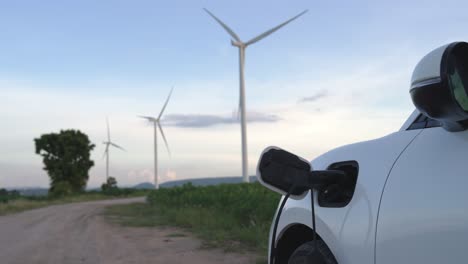 progressive combination of ev car, charging station and wind turbine.