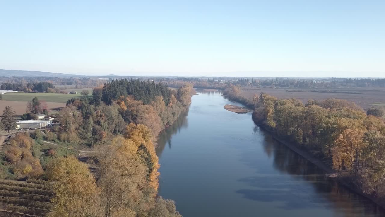 aerial footage of the willamette river south of Portland Oregon and the surrounding farm land. drone moving forward over river.