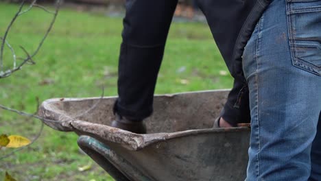 Un-Joven-Rastrillando-Hojas-Caídas-En-El-Patio-Trasero-De-Una-Casa-De-Campo-En-Un-Cálido-Día-De-Otoño