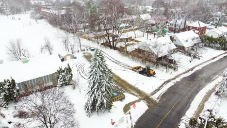 loader plowing snow to clear the road during blizzard in longueuil, quebec, canada