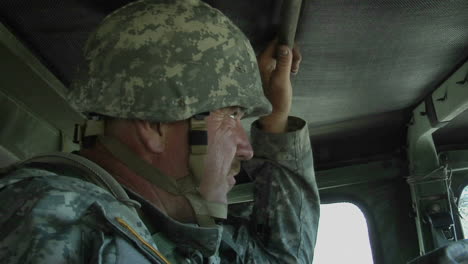 a soldier rides in an armored vehicle