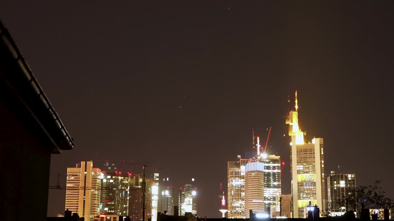 vista nocturna del horizonte de fráncfort con edificios iluminados bajo un cielo estrellado, time-lapse