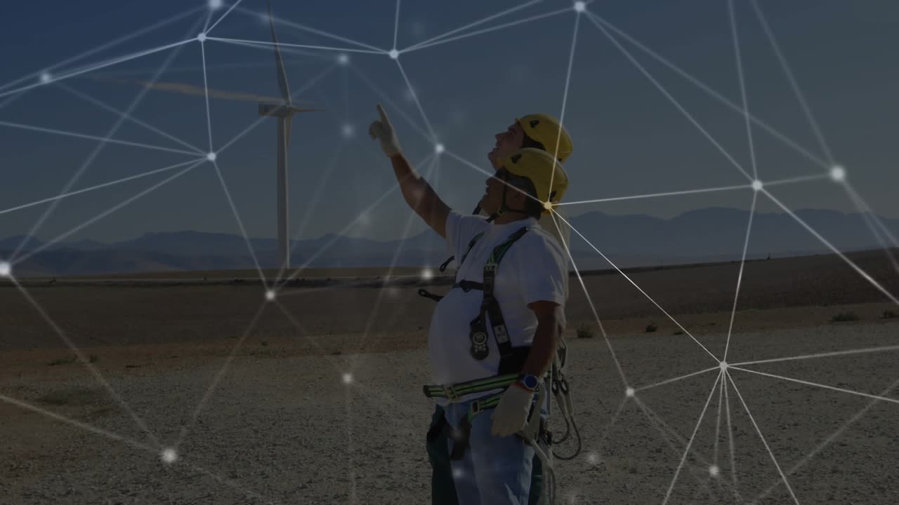 Technicians approaching turbine base while reviewing sensor status and monitoring network overlay