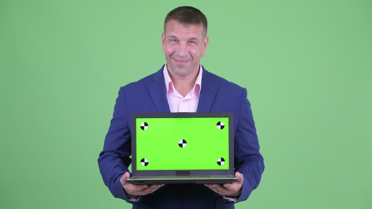 retrato de un musculoso y guapo hombre de negocios con traje contra el fondo verde del estudio