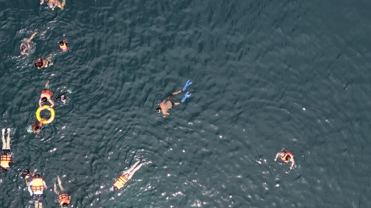 Anonymous People Snorkeling in Tropical Blue Water, Rising Drone Overhead