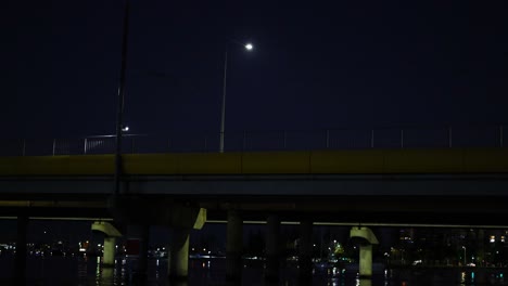 tram travels over canal bridge at night