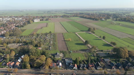 Aerial-of-green-meadows-at-the-edge-of-rural-town