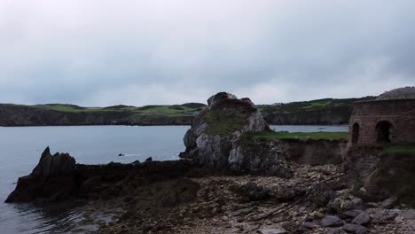 Panning-across-Anglesey-coastal-countryside-Porth-Wen-unused-brickwork-dome-furnace-ruins