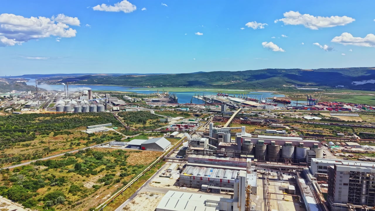Zona industrial con buques de carga y tanques de almacenamiento cerca de un río en un día despejado en una región costera