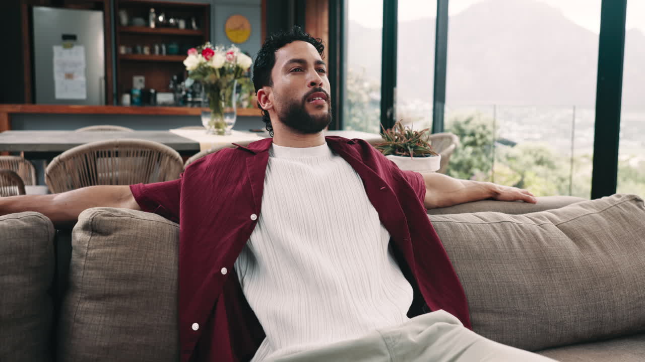 Giovane uomo che si rilassa comodamente su un divano in una casa moderna.