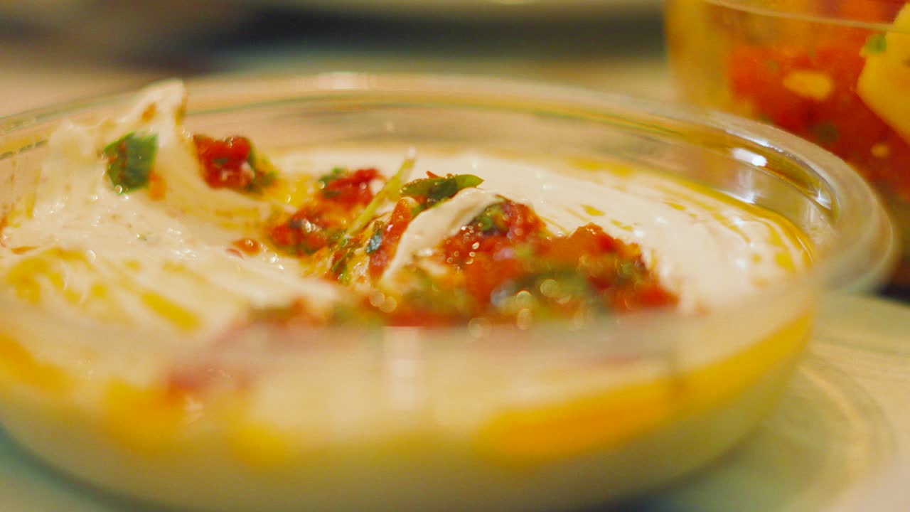 Slow Motion of Hand Scooping Garlic Aioli Sauce onto Freshly Baked Bread for Healthy Snack