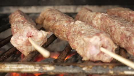 close up view of mititei on griller grilled over charcoal for main course