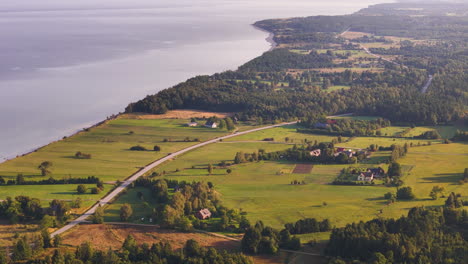 aerial flyover large development land (empty farmland) in strante, saka parish, latvia.