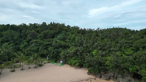 A-stunning-aerial-view-of-a-tropical-beach-next-to-tree-covered-hills-in-Catanduanes,-capturing-the-beauty-of-nature's-contrast