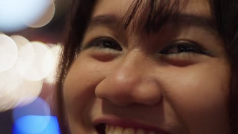 indonesian girl smiling sweetly at camera, with a blurry background