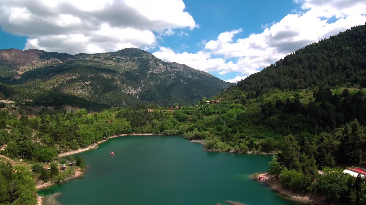 deslizando a la derecha la toma del dron de la vista del lago tsivlou desde arriba con montañas verdes que rodean pacíficamente las aguas naturales