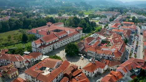 an aerial view capturing 'santa mafalda de arouca monastery' and the surrounding town in aveiro, a district in portugal, taken with a drone