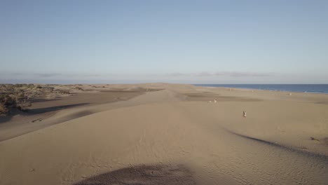 people walking at maspalomas golden sand dunes, stunning sunset, gran canaria