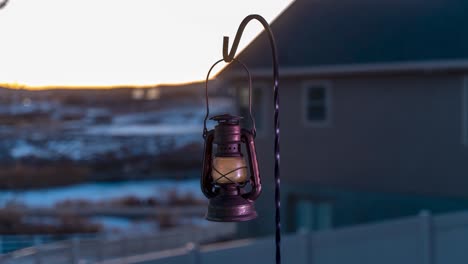 rusty, vintage lantern in a day-to-night time lapse with the city lights in the background - motion time lapse