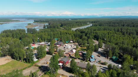 4k drone video of downtown talkeetna, ak along the susitna river with denali mountain in distance on sunny summer day