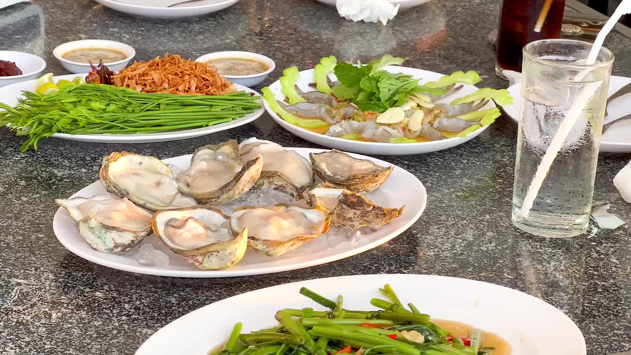 맛있는 오스트리와 초록색이 테이블에 있습니다.