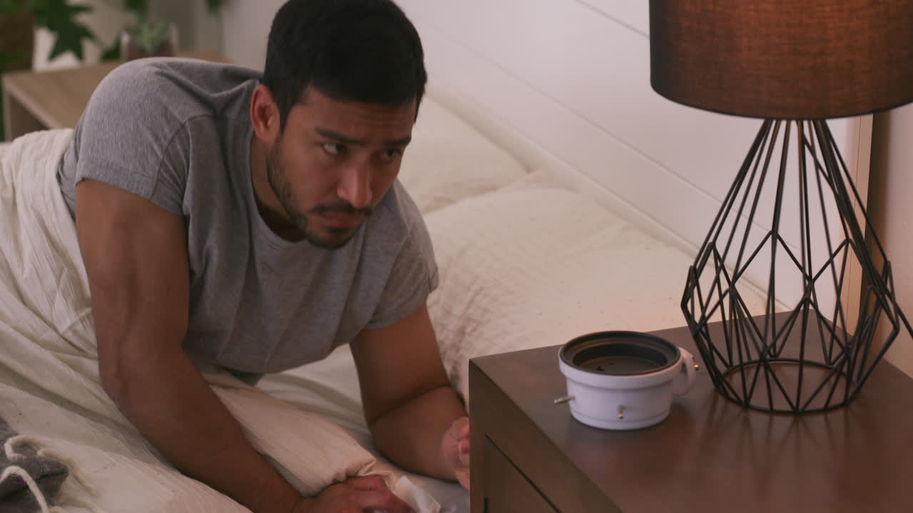 A man is lying in bed with a headache