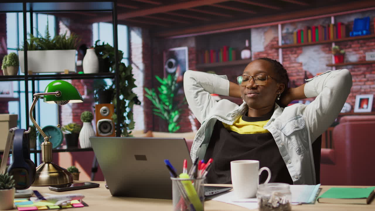 Joyous woman relaxing at home, sitting back and watching TV show on laptop