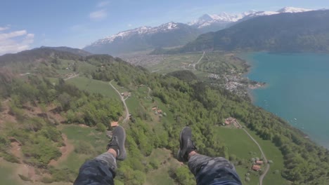 Standpunktaufnahme-Eines-Gleitschirms,-Der-An-Einem-Sonnigen-Tag-über-Den-üppigen-Berg-Und-Den-Ruhigen-Blauen-See-In-Der-Schweiz-Fliegt-–-Luftaufnahme-–-Pov