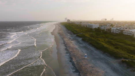 Drone-flyover-of-the-Brigantine-beach,-hazy-sunrise-in-Jersey-shore,-United-states