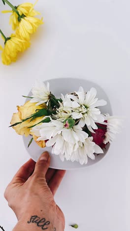 hand holding plate with flower arrangement