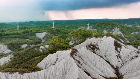 Torre-De-Transmisión-En-La-Antigua-Zona-Del-Volcán-De-Lodo-De-Tianliao-Durante-El-Día-Brumoso-En-Taiwán---Vuelo-Aéreo-Hacia-Adelante